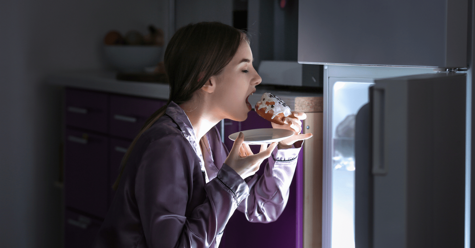 Mujer con diabetes experimentando sensación de hambre constante, sentada a la mesa con expresión de apetito.